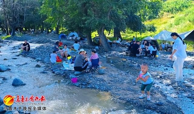 　　7月28日，在乌鲁木齐县高潮村青龙潭景区，游客在小溪边纳凉休闲。记者陈岩摄