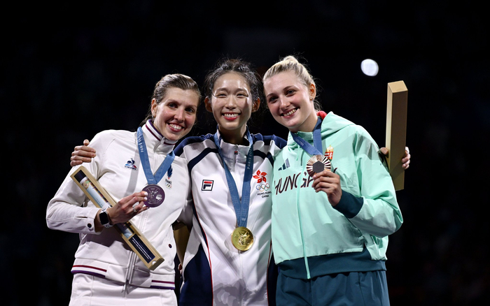 　巴黎奥运会击剑女子个人重剑夺冠后，江旻憓（中）与亚军、季军选手在颁奖仪式上合影。 图/新华社