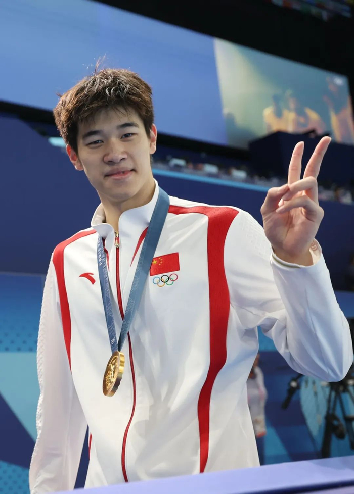 图为潘展乐面对镜头比出胜利的手势。