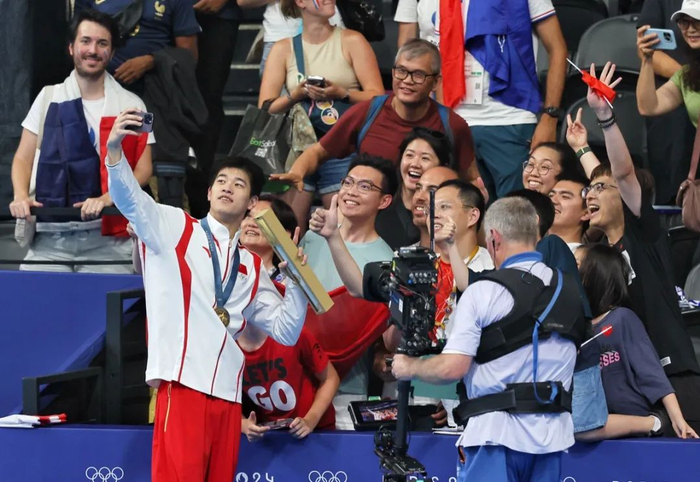 图为潘展乐与现场的中国观众们自拍留念。