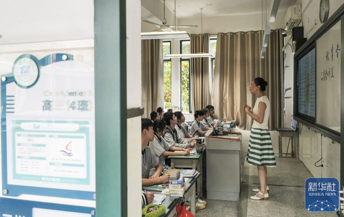 ▲某地一名教师正在课堂上与学生们交流。图/新华社