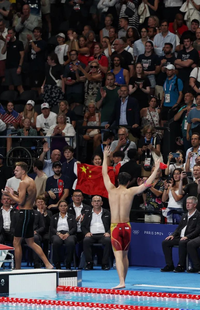 图为潘展乐出水后向看台上的观众们挥手致意。