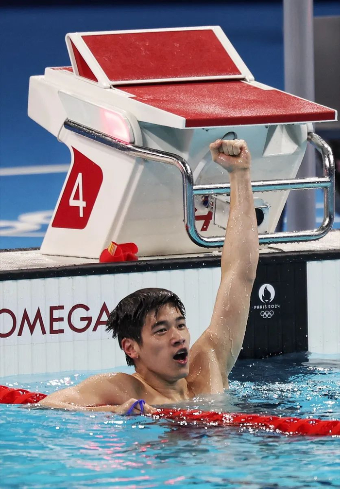 图为潘展乐夺冠后在水中庆祝。