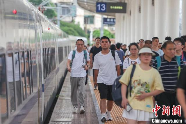 图为7月12日，江西南昌站，旅客从站台上走过。刘力鑫 摄