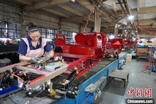 7月30日，河南洛阳偃师区，工人正在组装三轮摩托车。 中新社记者 韩章云 摄
