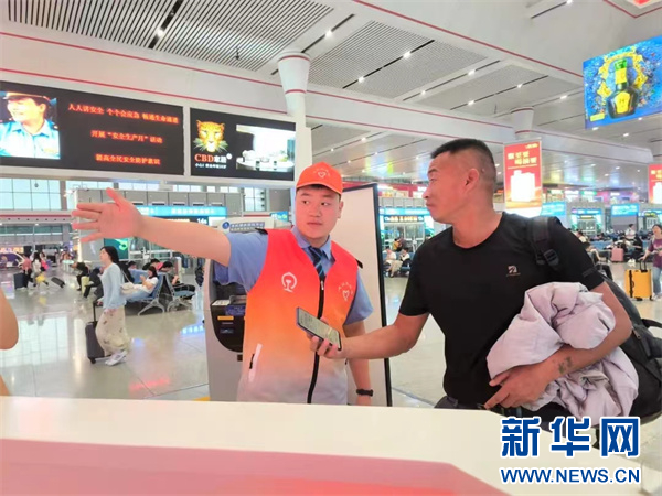 贵阳北站志愿者引导旅客。