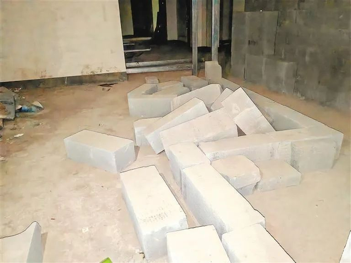 8号楼3单元人防区域的地上凌乱地堆放着一些建筑材料