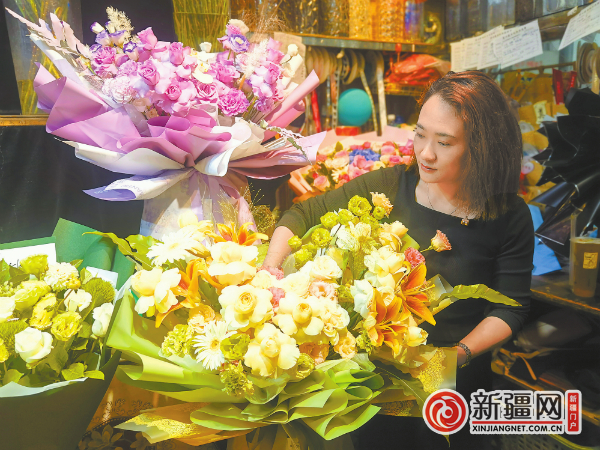 8月8日，爱心花店老板任洁正在为顾客整理用淡黄色奶油杯玫瑰为主制作的蝴蝶翅膀造型的花束。（全媒体记者李宁艳摄）