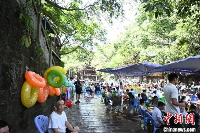 8月11日，在重庆北碚金刀峡镇的偏岩古镇河滩，民众在水中进行形式多样的娱乐活动，寻觅清凉。张旭 摄 