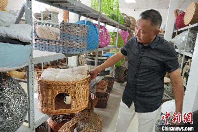 杨毅在介绍柳编猫窝。中新网记者 张娅子 摄