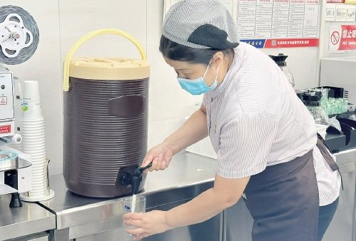 　　鲜奶吧中，工作人员为顾客提供新鲜牛奶。　农民日报·中国农网记者　杨惠　摄