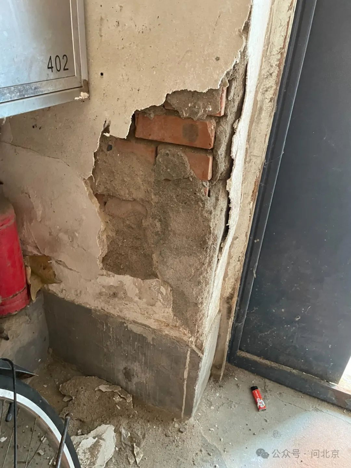 进入楼内,破损情况让人心惊,居民李阿姨随手一戳单元楼内的外墙,白色