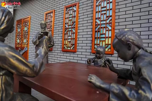 　　位于明德路的简易识字学塾主题的雕塑。（8月13日摄）记者米热扎提·木塔力甫摄