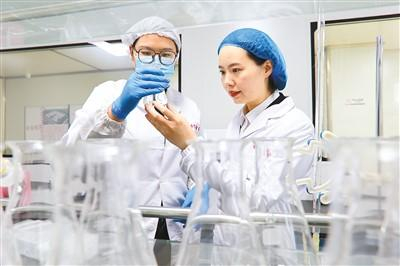 王宁（右）在化验室和检验人员一起查看质量检测样本。陈征摄