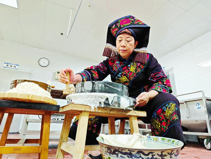 黄天玲使用石磨将浸泡后的大米磨成米浆，用于制作生榨米粉。本报记者梁枫 摄