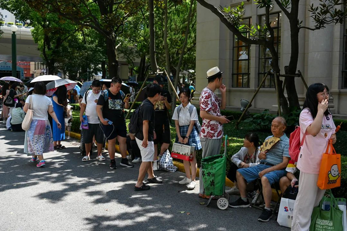 2024年8月17日，上海展览中心，老人坐在凳子上排队等候马伯庸的《食南之徒》签售活动。澎湃新闻记者 朱伟辉 图