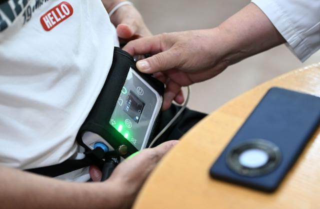 8月14日，泰达国际心血管病医院院长刘晓程在查看患者的“火箭心”控制器。新华社记者 李然 摄