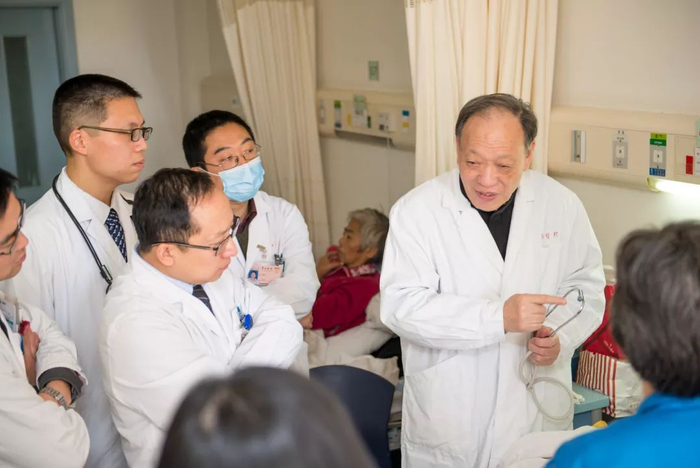 查房之余，翁心华教授指导年轻医生做个既拿书又拿听诊器的医生。