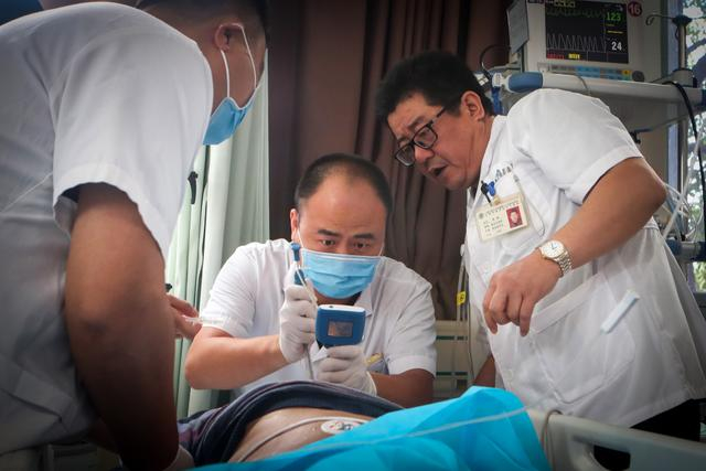 上海市奉贤区中心医院急诊医学科主任陈康（右）救治病人。受访者供图