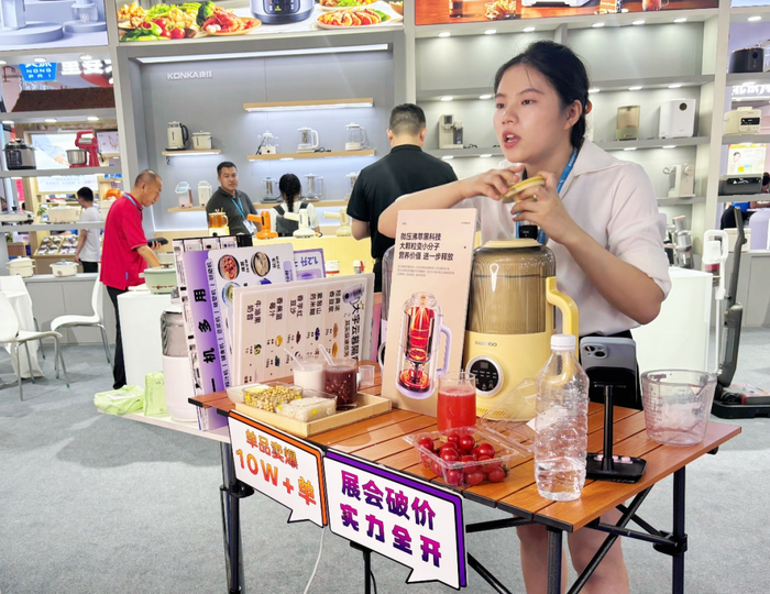 图为展商工作人员在介绍小家电产品。