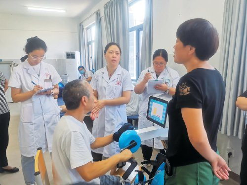 　　河洛镇卫生院康复科医生正在指导患者进行康复训练。　受访者供图