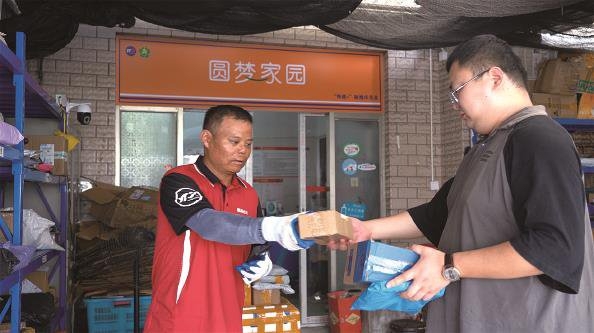             黄凯辉（左）把快递交给居民  采访对象供图          