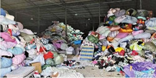 江苏省南京市江宁区一家旧衣分拣厂内堆放的衣物。图片源自人民网江楠摄