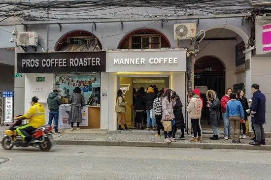 2020年12月15日，上海两家紧挨着的咖啡馆前，众多年轻人排起了长队买咖啡。视觉中国供图（资料配图）