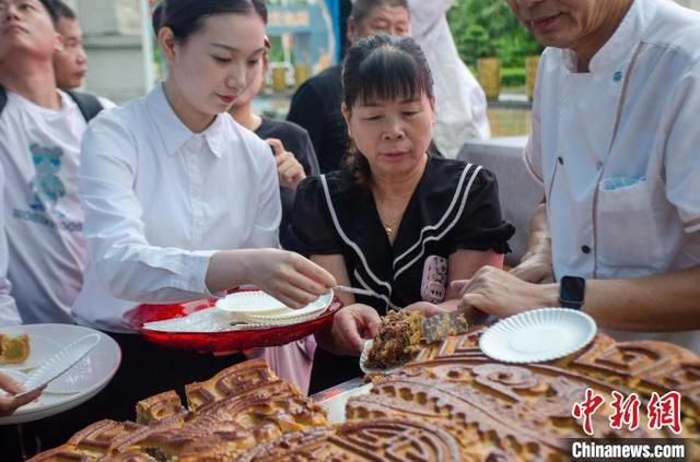 合浦月饼小镇2024年月饼文化周活动现场，民众分享大月饼。翟李强 摄