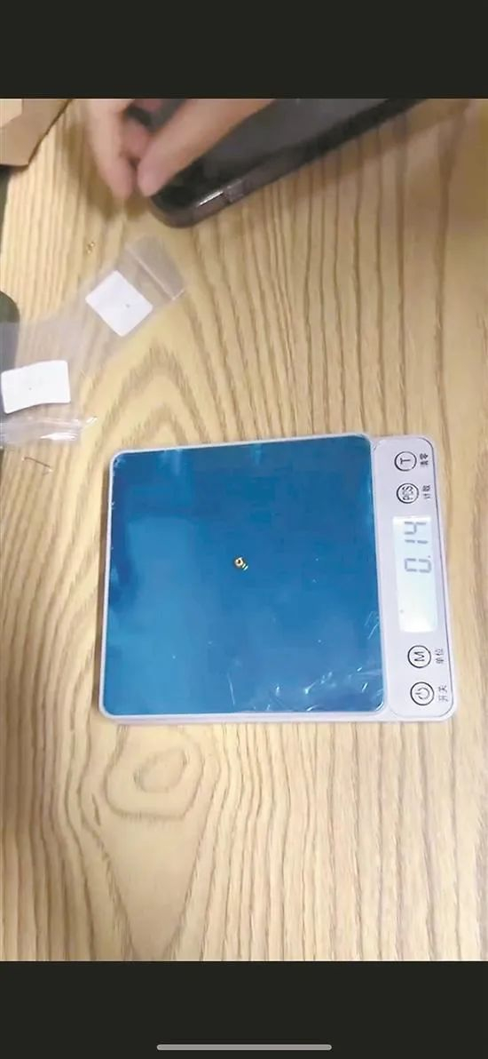 朱女士收到的发货单标注0.21克，但克重秤却显示0.14克 图/受访者提供