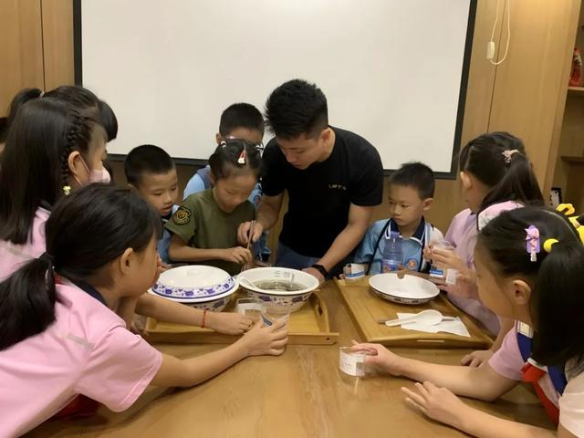 ▲闽南土笋冻制作技艺市级代表性传承人陈伟旭（中）为孩子普及土笋冻制作知识。