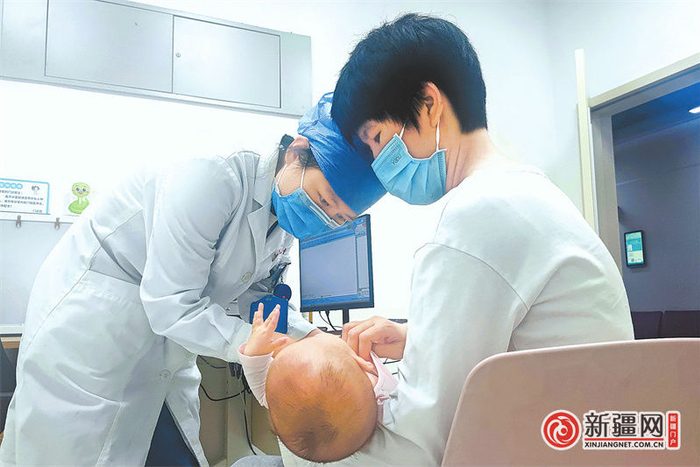 8月26日晚，在北京儿童医院新疆医院延时门诊，医生正在为一名患儿检查。（全媒体记者李晓青摄）
