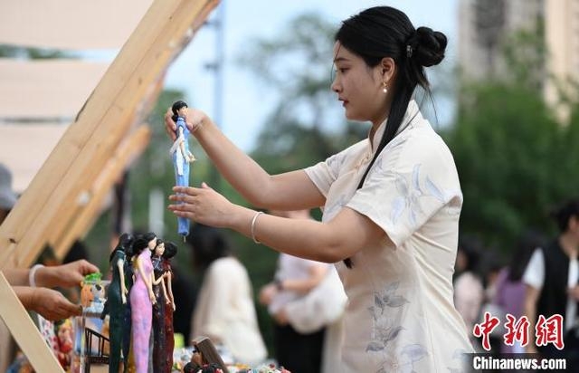 图为游客在欣赏旗袍造型的商品。中新社记者 于海洋 摄 