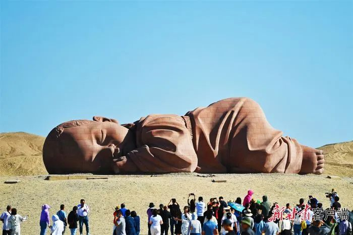 游客在瓜州戈壁国际雕塑艺术长廊“大地之子”雕塑前打卡。新甘肃·甘肃日报记者 董文龙摄