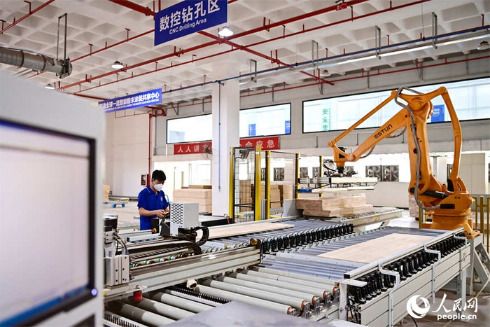 位于赣州市南康区镜坝镇的家具零部件共享智能工厂,工人在批量加工