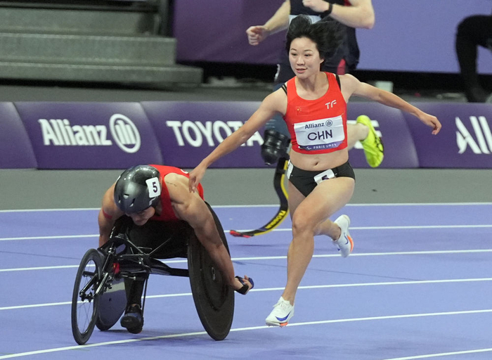 9月6日，中国队第三棒选手文晓燕（右）与队友胡洋在比赛中接力。新华社记者 才扬 摄