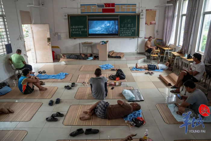 徐闻县实验中学课室，司机们在安置点内观看电影