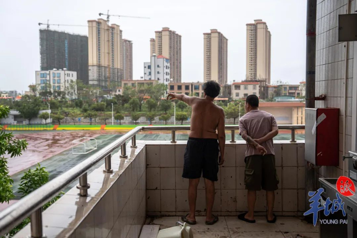 司机们站在阳台观望台风过后的路面情况