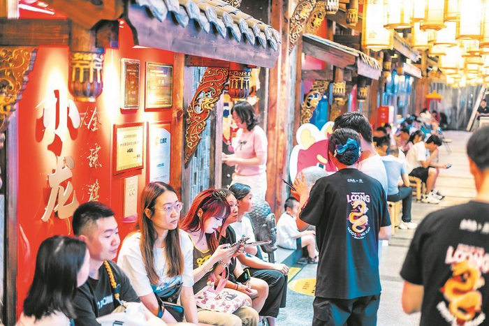     火锅店门口坐满了等待的食客