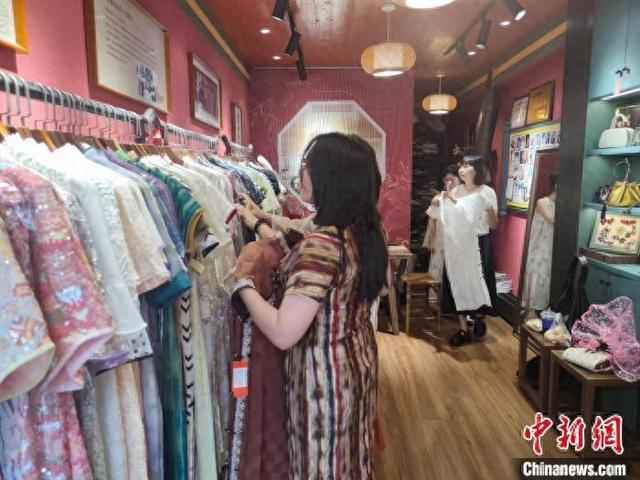 9月14日，顾客在尹晓波的店铺选购旗袍。傅飞扬 摄
