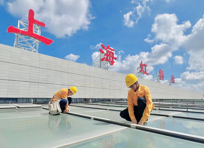 上海房建公寓段职工在站房屋顶进行加固作业。  李绪文  摄