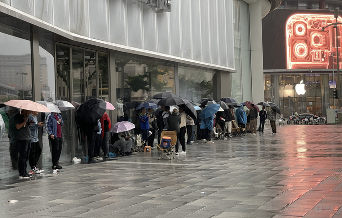 华为门口熬夜排队的人与马路另一侧的苹果店，钛媒体APP拍摄