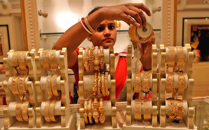 ▲资料图：印度加尔各答，售货员在展示黄金手镯。图/IC photo