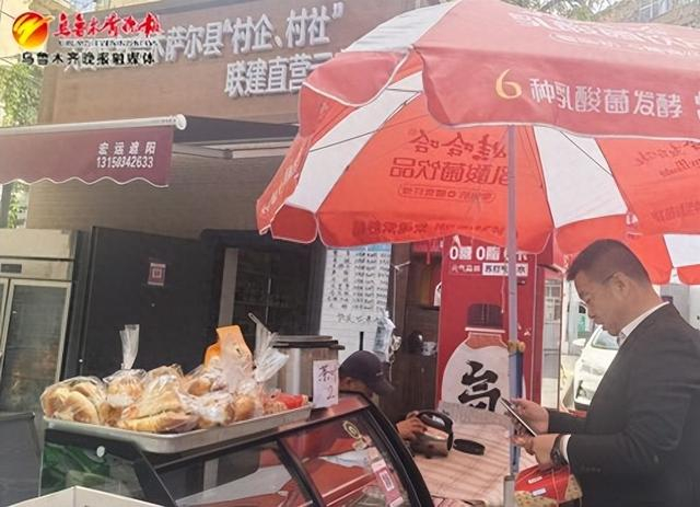 　　9月21日，在春风巷小区天山区与吉木萨尔县“村企、村社”联建直营店门口，居民正在购买物品。记者王媛媛摄