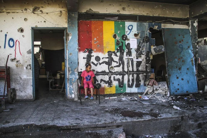 9月21日，在加沙地带北部加沙城，一名女孩查看以军袭击后的废墟。新华社发（马哈茂德·扎基摄）　