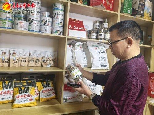 　　9月21日，在春风巷小区天山区与吉木萨尔县“村企、村社”联建直营店门口，居民正在购买物品。记者王媛媛摄