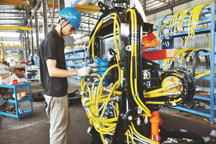     ▲广西徐沃工程机械设备有限公司产品热销海内外。图为公司生产线上，工人正在调试机器。