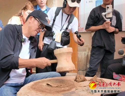 　　俞敏洪在墨玉县体验桑皮纸制作过程——捶捣。 墨玉县融媒体中心供图