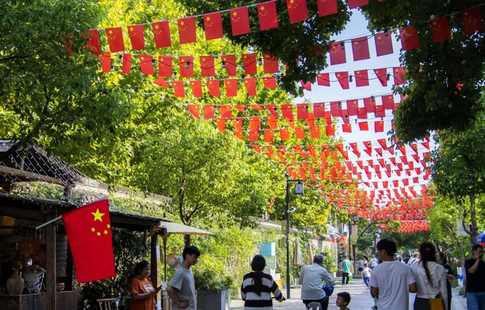 江都区政府门口装扮一新迎国庆△市民在三湾公园里与国旗合影△扬 
