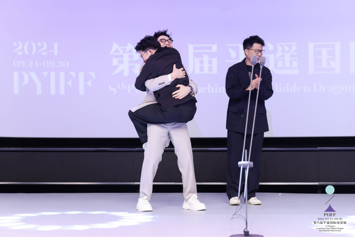 导演杨穗益激动得跳着挂到大鹏身上